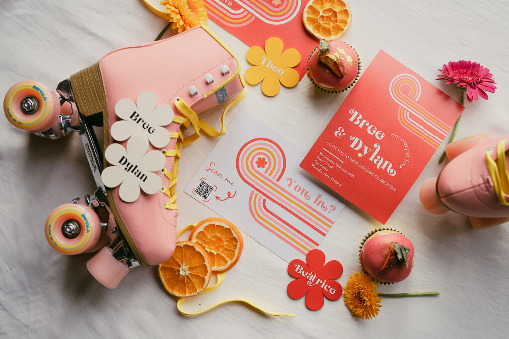 Flat lay featuring pink rollar skates with yellow laces and various retro placenames shaped like flowers