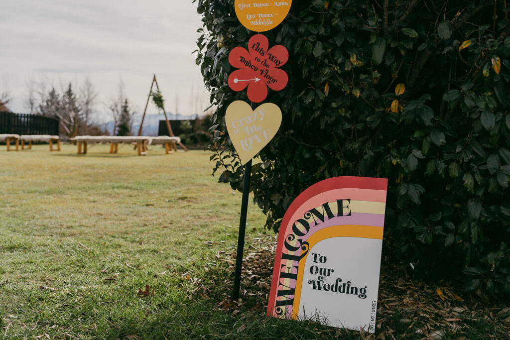 Wedding branding of colourful retro with signage for a welcome and directions post.