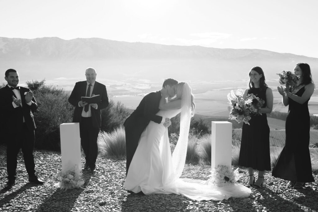 Bride and Groom first kiss after getting married in black and white