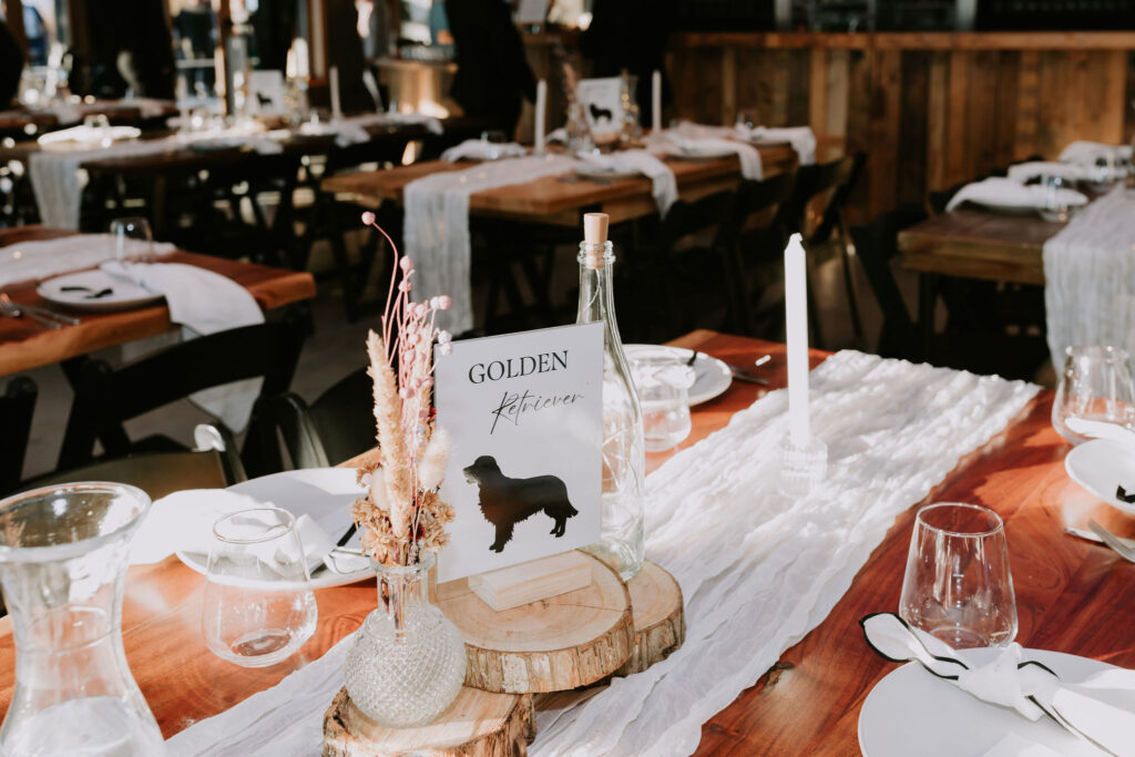 Table scape with dried flowers, glass bottles and taper candles.