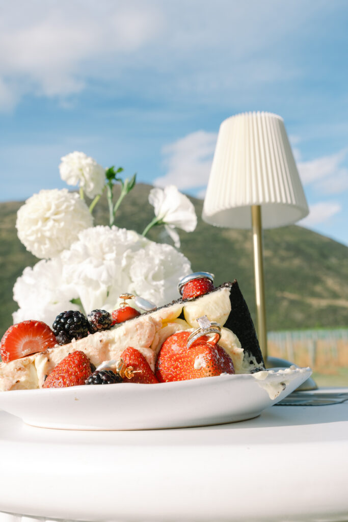 Wedding rings and earrings styled with berries and cream cake at Mt Rosa reception