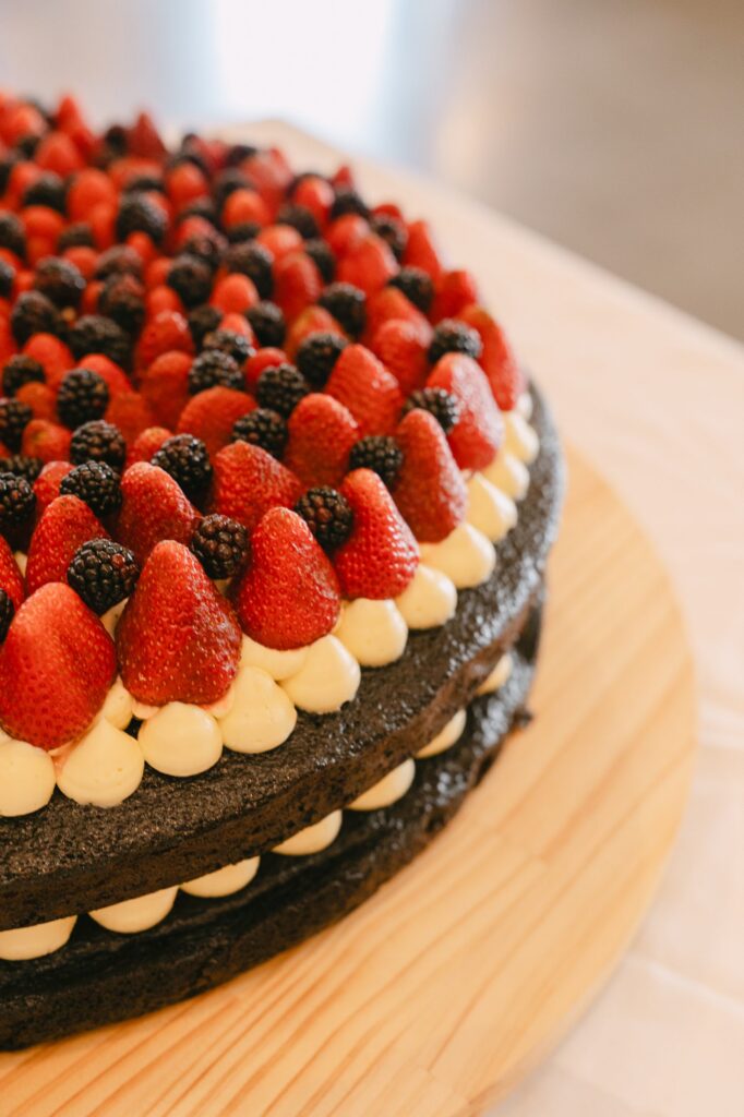 Chocolate wedding cake topped with fresh strawberries and blackberries, close-up detail